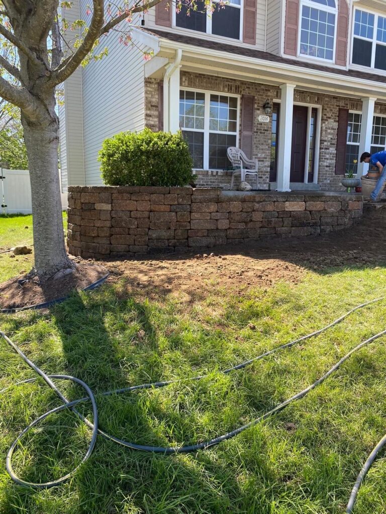 Contractor building a stone retaining wall in a Saint Louis backyard.