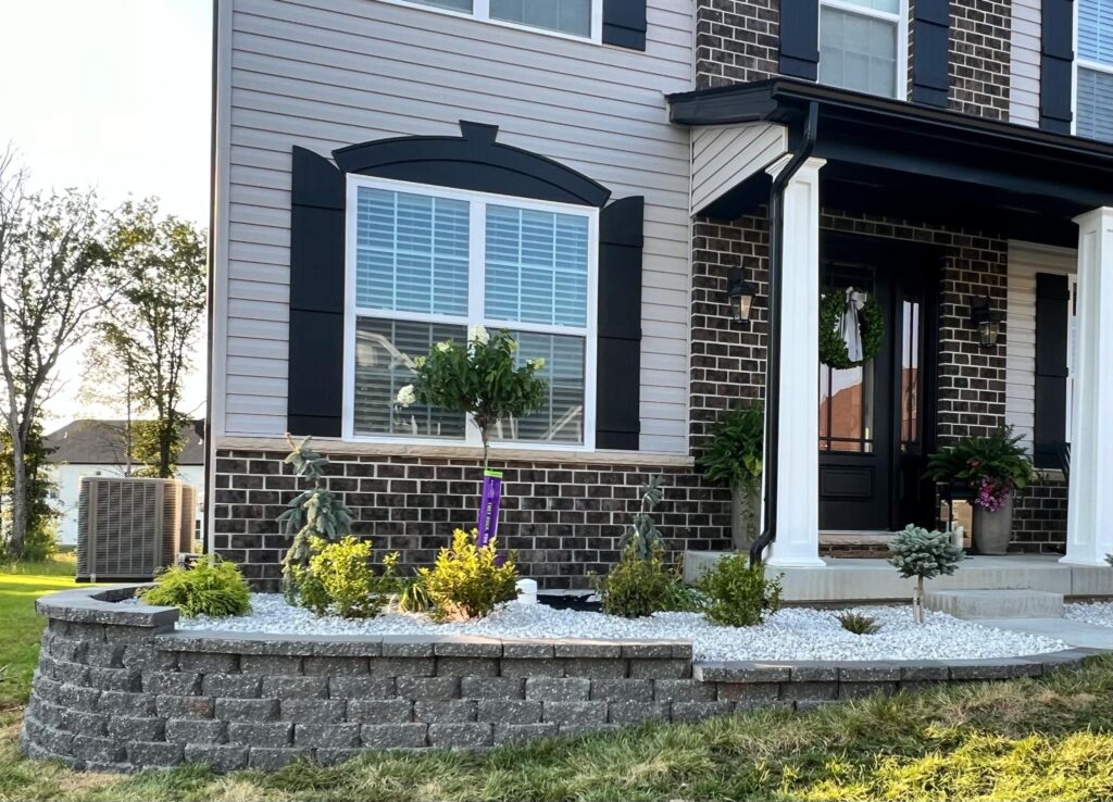 Contractor building a stone retaining wall in a Saint Louis backyard.