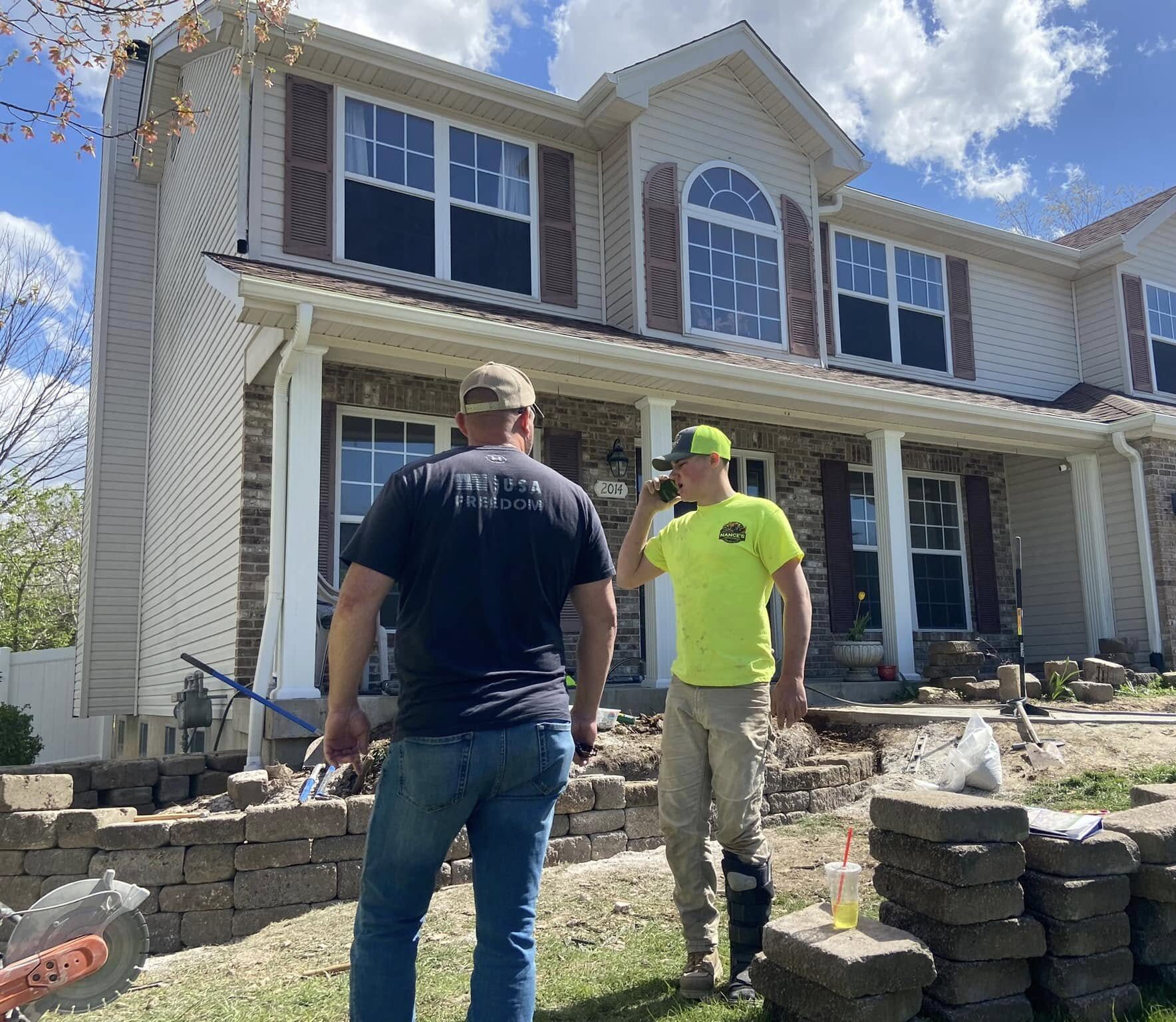 Contractor building a stone retaining wall in a Saint Louis backyard.