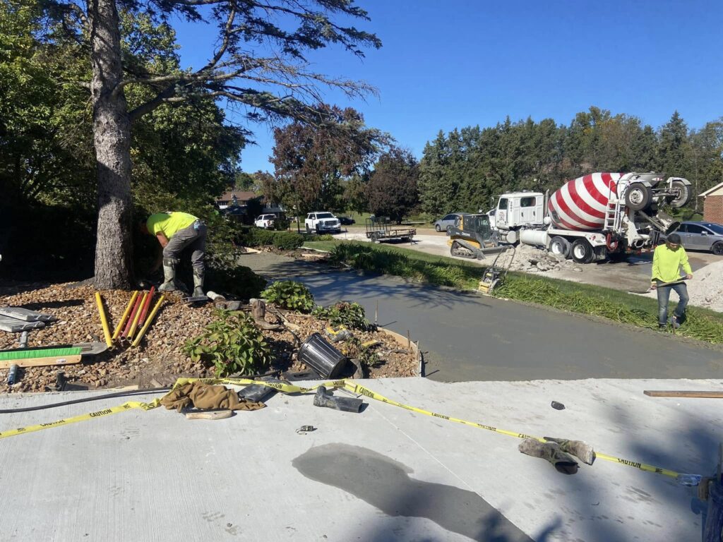 Contractor smoothing fresh concrete on a driveway in Saint Louis.